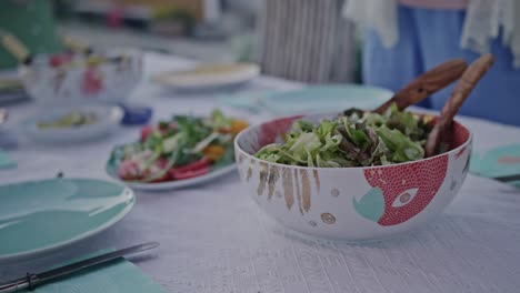 A-bowl-of-healthy-green-salad-beautifully-presented-on-a-dinner-table-adorned-with-colorful-tableware