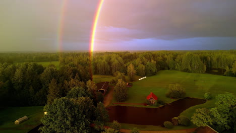 Aerial-drone-view-of-a-double-rainbow-in-the-countryside-on-a-cloudy-day