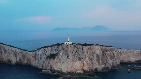 Aerial-View-Of-Lighthouse-Atop-Lefkada-Island-With-Misty-Landscape-Sea-In-Background