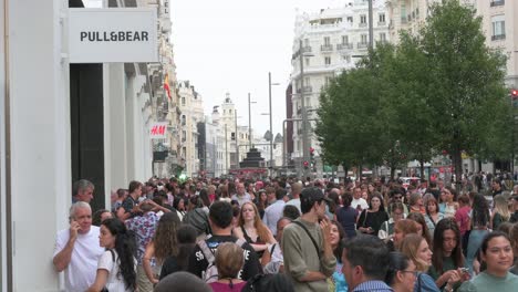 Large-crowds-of-pedestrians-and-shoppers-are-seen-walking-past-the-Spanish-multinational-clothing-design-retail-company-by-Inditex,-Pull-and-Bear-store