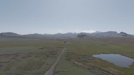 Vista-Desde-Arriba,-Camino-Rural,-Glaciar-Y-Iglesia-Ingjaldshóll-En-La-Distancia,-Islandia