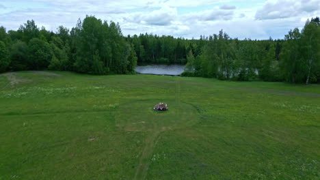 Aerial-drone-establishing-shot-of-a-green-forest-landscape-with-a-lake