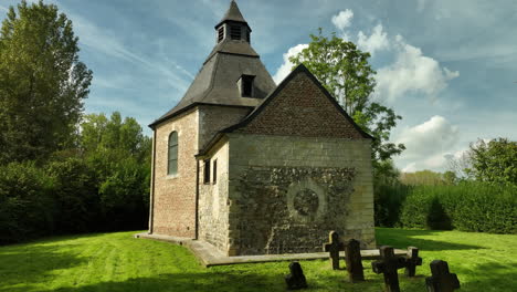 Tiny-Old-Chapel-with-Gravestones,-Dolly-In-Tilt-Up-Low-Angle,-Offelken