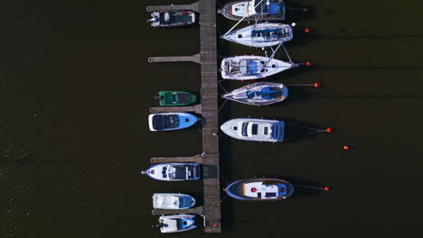 Top-shot-of-small-boats-docked-on-a-small-pier-or-dock-in-Helsinki,-Finland,-single-row