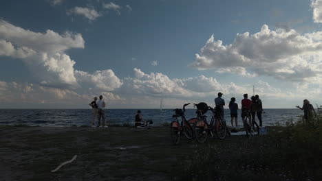 Wide-view-of-a-small-crowd-of-cyclists-gathered-together-by-Lake-Ontario