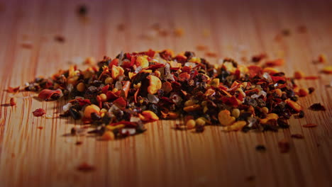 A-pile-of-chili-spice-mix-on-a-wooden-surface-with-dramatic-lighting,-camera-orbiting