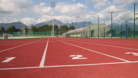 Athletic-track-with-mountains-in-the-background,-dolly-right-shot