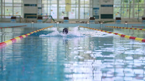Schwimmerin-Beim-Brustschwimmen-Im-Hallenschwimmbecken,-Vorderansicht