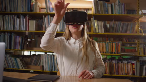 Teen-girl-using-VR-headset-while-sitting-in-the-school-library,-handheld-shot