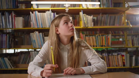 Teenager-Mädchen-Lernt-In-Der-Bibliothek,-Denkt-über-Eine-Schulaufgabe-Nach,-Handaufnahme