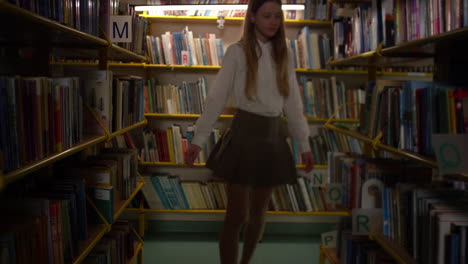 Schoolgirl-choosing-a-book-for-reading-in-the-school-library,-handheld-shot