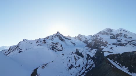 Wunderschöne-Malerische-Luftaufnahme-Des-Schneebedeckten-Gletschergipfels-Der-Alpinen-Bergkette-An-Einem-Morgen-Mit-Blauem-Himmel