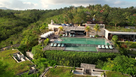 Tropical-Hotel-and-Resort-on-Hilltop-with-Large-Swimming-Pool-Lounge-at-Maua-Nusa-Penida,-Aerial-Revealing