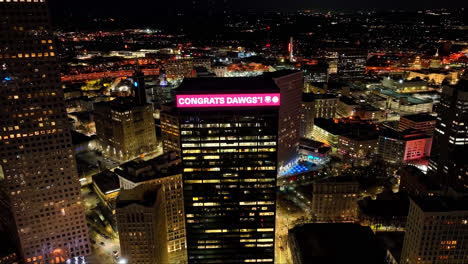 Drone-approaching-shot-of-Skyscraper-in-Atlanta-with-Congrats-Dawgs-Information-on-billboard