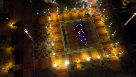 Aerial-top-down-shot-of-led-lighting-Olympic-rings-on-ground-in-city-of-Atlanta-at-night---Fountain-of-rings
