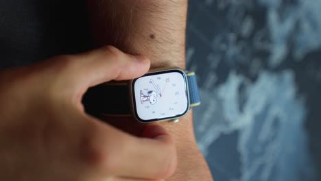 Male-hands-checking-new-modern-Apple-watch-7-functions-by-pushing-buttons-and-touching-screen