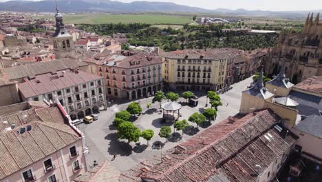 Plaza-Mayor-in-Segovia-Spain,-aerial-circling-above-rooftops,-sunny-day