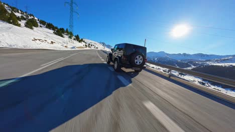 Epic-FPV-aerial-drone-tracking-a-black-Jeep-along-a-scenic-mountain-highway