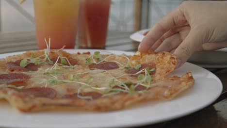 Close-up-shot-of-sliced-pizza-being-picked-up,-slow-motion