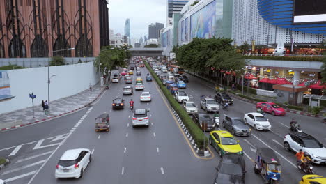 Afternoon-traffic-rush-hour-in-front-of-MBK,-a-famous-shopping-in-the-heart-of-the-city-of-Bangkok,-Thailand-in-Southeast-Asia