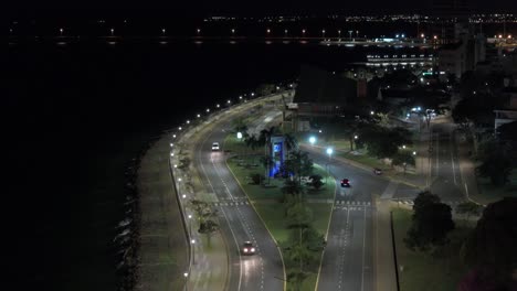 Aerial-view-of-city,-waterfront,-and-cars-driving-at-night-in-beautiful-Posadas,-Misiones,-Argentina