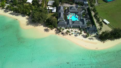 Drone-flying-over-beachfront-luxury-resort-in-Rarotonga,-Cook-Islands