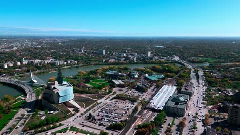 Gründungsaufnahme,-Herbstsaison,-Drohne,-Filmische-Luftaufnahme,-Herbst,-Innenstadt-Von-Winnipeg,-Landschaft,-Himmel,-Horizont-Mit-Via-Rail,-Kanadisches-Museum-Für-Menschenrechte,-Provencher-Bridge,-The-Forks-Market,-Manitoba,-Kanada