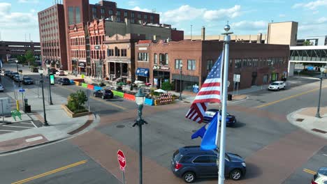 American-and-Minnesota-flags-weaving-at-square-in-Saint-Cloud,-MN
