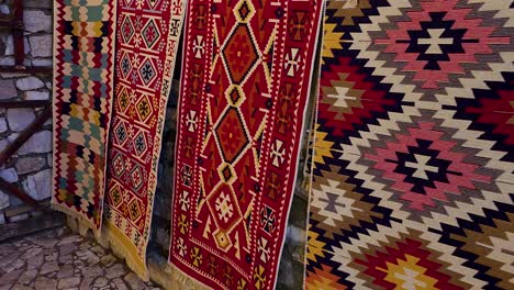 Teppiche-Schmücken-Die-Steinmauern-Der-Burg-Berat,-Handgefertigte-Wandteppiche-Aus-Farben-Und-Formen-In-Albanien