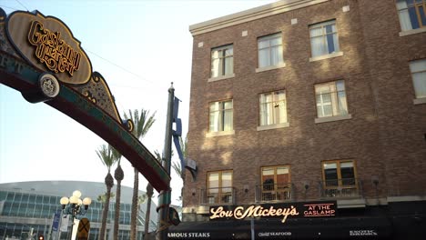4K-video-captures-the-Gaslamp-Quarter-San-Diego-Sign,-panning-to-Lou-and-Mickey's-restaurant-on-September-26,-2023,-with-the-Convention-Center-in-the-backdrop