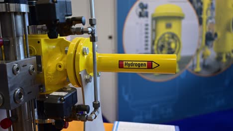 The-word-hydrogen-is-written-on-a-yellow-pipe-which-is-part-of-a-demonstrator-of-special-shut-off-valves-on-a-trade-fair,-zoom-out