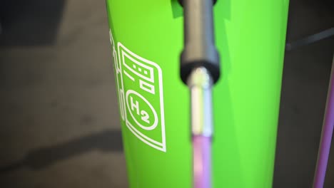 Das-Piktogramm-Einer-Wasserstofftankstelle-Auf-Grünem-Hintergrund,-Anschluss-An-Einer-Leitung,-Kraftstoffpumpe