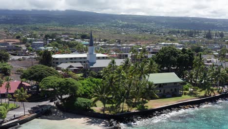 Wide-panning-aerial-shot-of-the-Hulihe'e-Palace,-the-royal-Hawaiian-vacation-home-in-Kailua-Kona,-Hawai'i