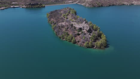 Luftaufnahme-über-Eine-Kleine-Waldinsel-Im-Atemberaubenden-Grünen-See-Mit-Türkisfarbenem-Wasser-Im-Taurusgebirge-Der-Türkei