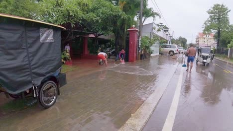 People-bailing-water-from-their-homes-after-torrential-rains-in-the-touris-hub-of-Siem-reap,-Cambodia