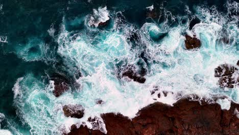 a-bird's-eye-view-of-a-rocky-shoreline-with-waves-crashing-on-it's-rocks-and-the-ocean