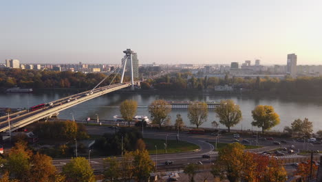 Bratislava,-Slovakia-on-Sunny-Autumn-Day,-Road-and-SNP-Bridge-Traffic,-Danube-River-and-Misty-Skyline