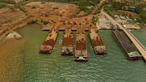 Aerial-drone-shot-showing-ships-or-barges-collecting-material-from-Nickel-Mines-in-Taganito,-Philippines