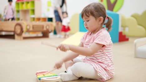 Active-Toddler-Girl-Strikes-Fast-on-Toy-Xylophone-Wooden-Keys-in-Playroom-Kids-Cafe--profile-view,-slow-motion