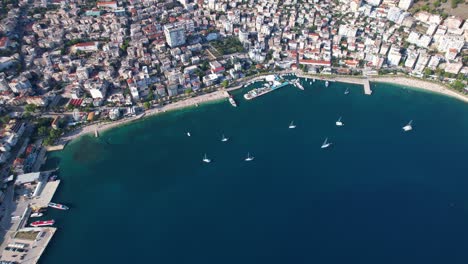 Aerial-View-of-Saranda-Bay:-Port,-Anchored-Ships,-Blue-Sea,-and-Sunken-Ship-in-this-Scenic-Touristic-Destination