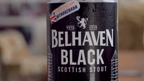 Condensed-droplets-sliding-down-a-Belhaven-Black-beer-can,-a-refreshing-visual-treat
