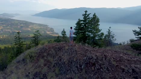 Wanderer-Steht-Am-Aussichtspunkt-In-Den-Kanadischen-Bergen-Mit-Blick-Auf-Den-Okanagan-See-Und-Das-Lakecountry-Im-Landesinneren-Von-British-Columbia