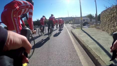 Cycle-training-Calpe-Spain-being-passed-by-a-group-of-Pro-Cyclists-a-small-town-on-a-winter-morning