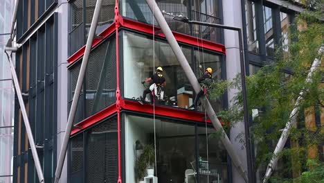 Cleaning-the-windows-at-the-NEO-Bankside-Building,-London,-United-Kingdom