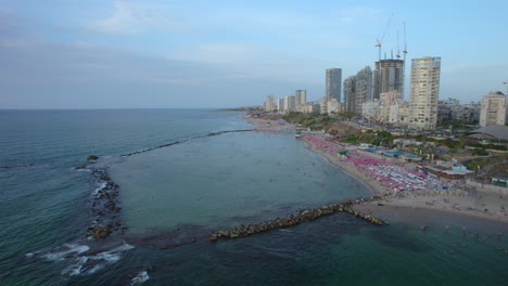 Bat-Yam-rock-Beach-is-packed-with-families-who-come-to-enjoy-the-shallow-water-with-children---The-lagoon-is-formed-by-wave-breakers