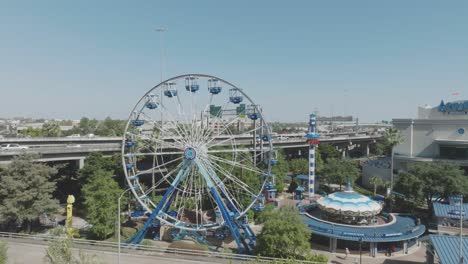 An-aerial-establishing-shot-of-The-Downtown-Aquarium-featuring-featuring-the-Diving-Bell-Ferris-wheel,-Aquatic-Carousel,-and-Lighthouse-Dive-under-blue-skies-in-downtown-Houston-Texas