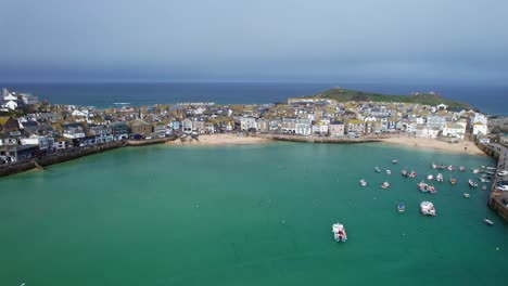 Scenic-Views-Overlooking-St-Ives-Coastal-Town-Harbor-with-Turquoise-Waters-and-Boats-on-a-Beautiful-Summers-Day-in-the-Southwest-of-England-with-an-Aerial-Drone-Shot