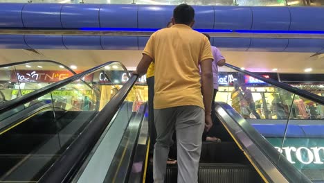 Follow-scene,-people-are-going-inside-the-mall-in-an-automatic-escalator-in-a-shopping-mall-and-many-people-are-coming-out-after-shopping