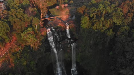 Drone-view-of-the-famous-Tad-Gneuang-Waterfall-at-Laos-during-sunset,-aerial