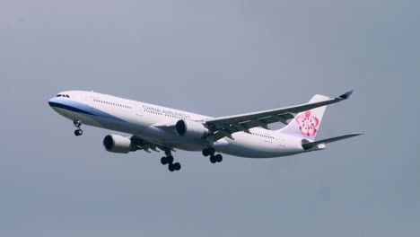 Ein-Airbus-Der-Chinesischen-Fluggesellschaft-Landet-Auf-Dem-Suvarnabhumi-Flughafen-In-Bangkok,-Thailand,-Und-Zeigt-Auch-Flauschige-Wolken-Und-Vorbeifliegende-Vögel